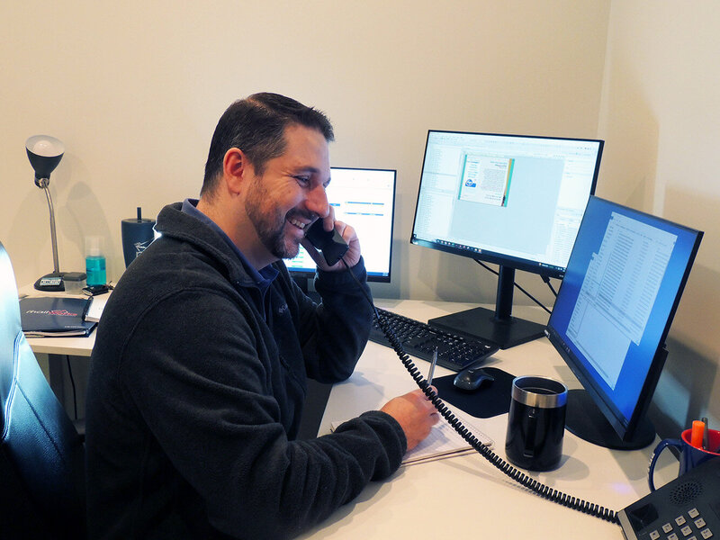 A Program Director at his desk, on the phone with a Partner
