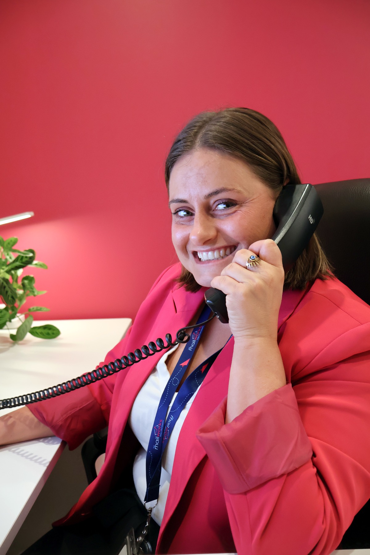 A Mailworks account manager smiling on a call at her desk
